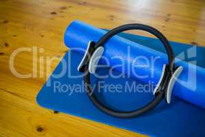 Pilates ring and exercise mat kept on wooden floor