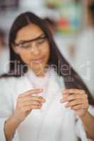 School girl experimenting with piece of glass in laboratory