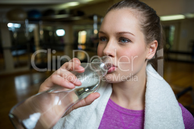 Beautiful woman drinking water after workout