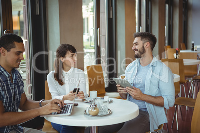 Executives interacting while using, mobile phone, digital tablet and laptop