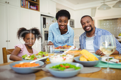 Portrait of happy woman serving food to the family