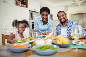 Portrait of happy woman serving food to the family