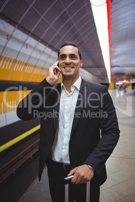 Executive talking on mobile phone on platform