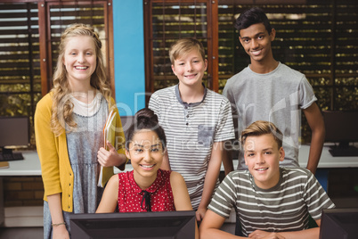 Portrait of smiling students studying in computer classroom