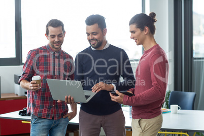 Businesspeople having discussion over laptop