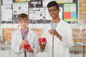 Portrait of smiling school kids doing a chemical experiment in laboratory