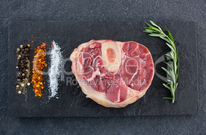 Sirloin chop, rosemary herb an spices on slate plate