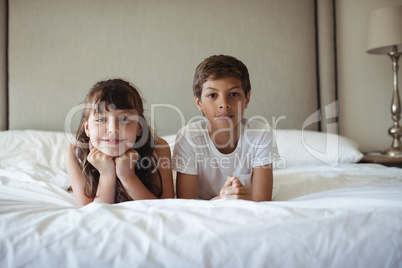 Siblings smiling in bed