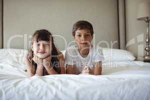 Siblings smiling in bed