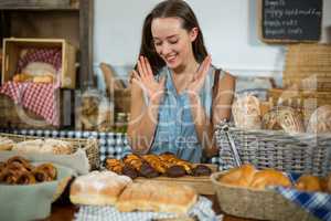 Excited female customer looking at tray of dessert at counter