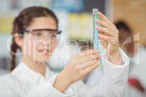 Schoolgirl experimenting molecule model in laboratory at school