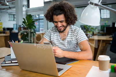 Graphic designer using mobile phone in creative office