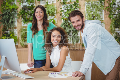 Team of graphic designers smiling at desk