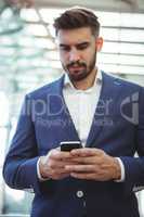 Attentive businessman using mobile phone