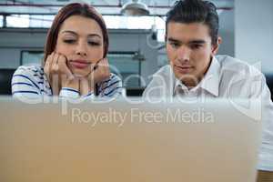 Man and woman working on laptop at desk