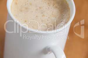 Close-up of white mug of coffee with creamy froth
