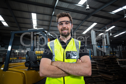 Portrait of factory worker standing with arms crossed