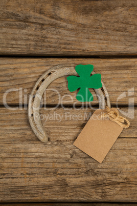 St Patricks Day horseshoe with empty tag and shamrock on wooden table
