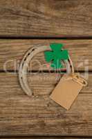 St Patricks Day horseshoe with empty tag and shamrock on wooden table
