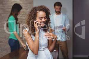 Female executive talking on mobile phone in office