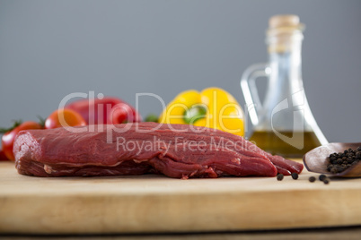 Beef steak and ingredients on wooden tray against wooden background