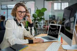 Woman talking on mobile phone at desk