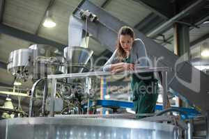 Female factory worker inspecting a storage tank