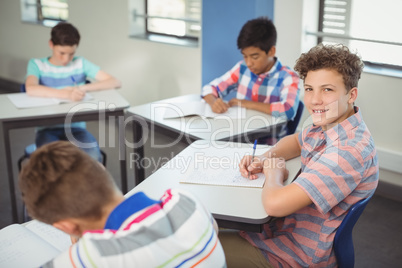 Schoolboy sitting at desk in classroom Schoolboy sitting at desk in classroom