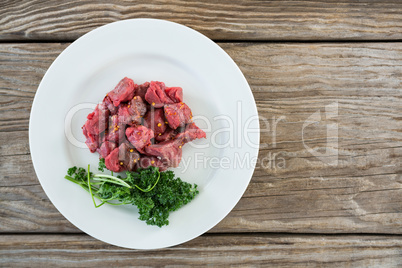 Diced beef and corainder leaves in white plate