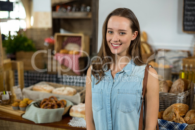 Portrait of smiling woman standing against counter