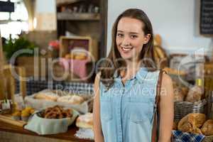 Portrait of smiling woman standing against counter