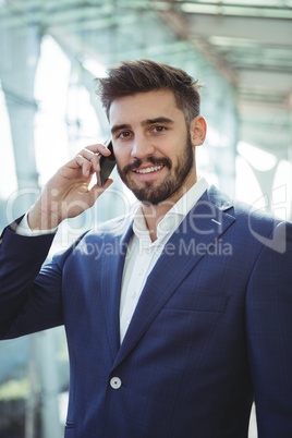 Businessman talking on mobile phone at railway station