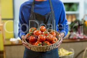 Vendor holding a basket of tomatoes