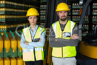 Factory workers standing with arms crossed in factory