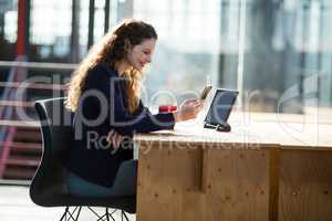 Female business executive using mobile phone at desk