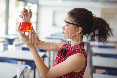 Attentive schoolgirl doing a chemical experiment in laboratory