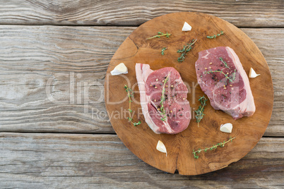 Sirloin steak, garlic and herb on wooden tray against wooden background