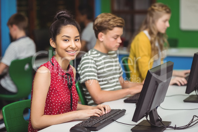 Smiling students studying in computer classroom