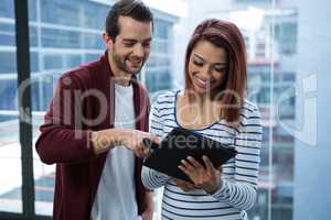 Man and woman discussing over digital tablet