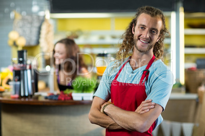 Smiling shop assistant standing in health grocery shop