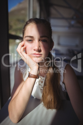 Worried schoolgirl sitting in classroom