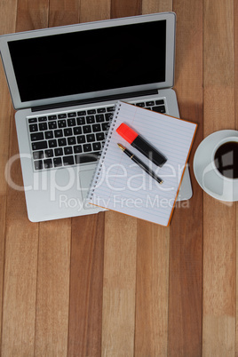 Cup of coffee with laptop, organizer, maker and pen