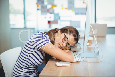 Female graphic designer sleeping on desk