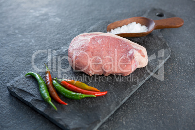 Sirloin chop, salt and chillies on slate plate