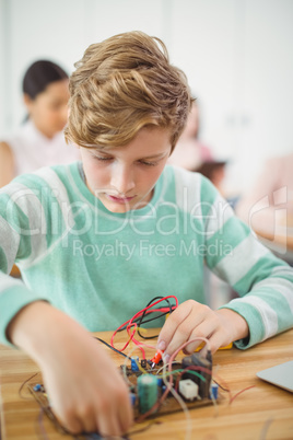 Schoolboy working on electronic project in classroom