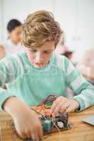 Schoolboy working on electronic project in classroom