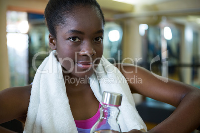 Portrait of happy woman holding water bottle after workout