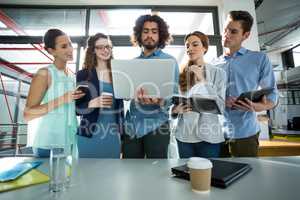 Business team discussing over laptop in meeting