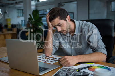 Worried man sitting with laptop at desk