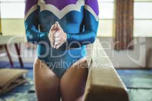 Female gymnast rubbing her hands with chalk powder
